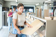 © JackF - Young woman buyer chooses sample of laminate flooring in hardware store