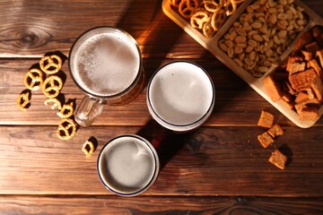 Canvas Print - Glasses with different types of beer and snacks on wooden table, flat lay