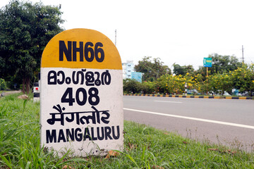 mile stone sign board (travel guide) located beside of national highway in kerala india