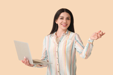 Female programmer with laptop on beige background
