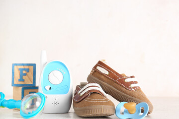 Canvas Print - Stylish baby shoes with cubes, rattle, pacifier and baby monitor on grunge white background