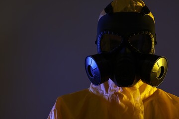Wall Mural - Worker in gas mask on dark background. Space for text