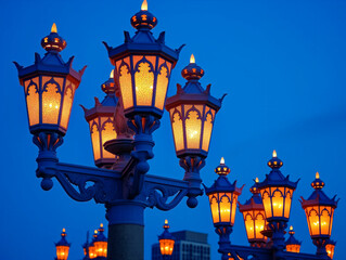 Wall Mural - A group of street lamps with lights on, creating a warm and inviting atmosphere. The lamps are arranged in a row, with some of them having a more prominent presence than others