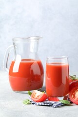 Wall Mural - Tasty tomato juice with fresh vegetables and basil leaves on light grey table