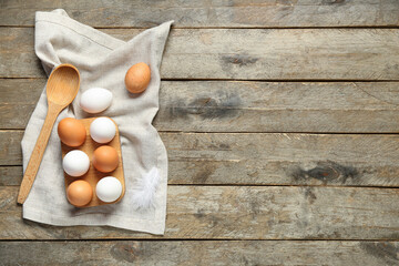 Wall Mural - Holder with raw chicken eggs on wooden background