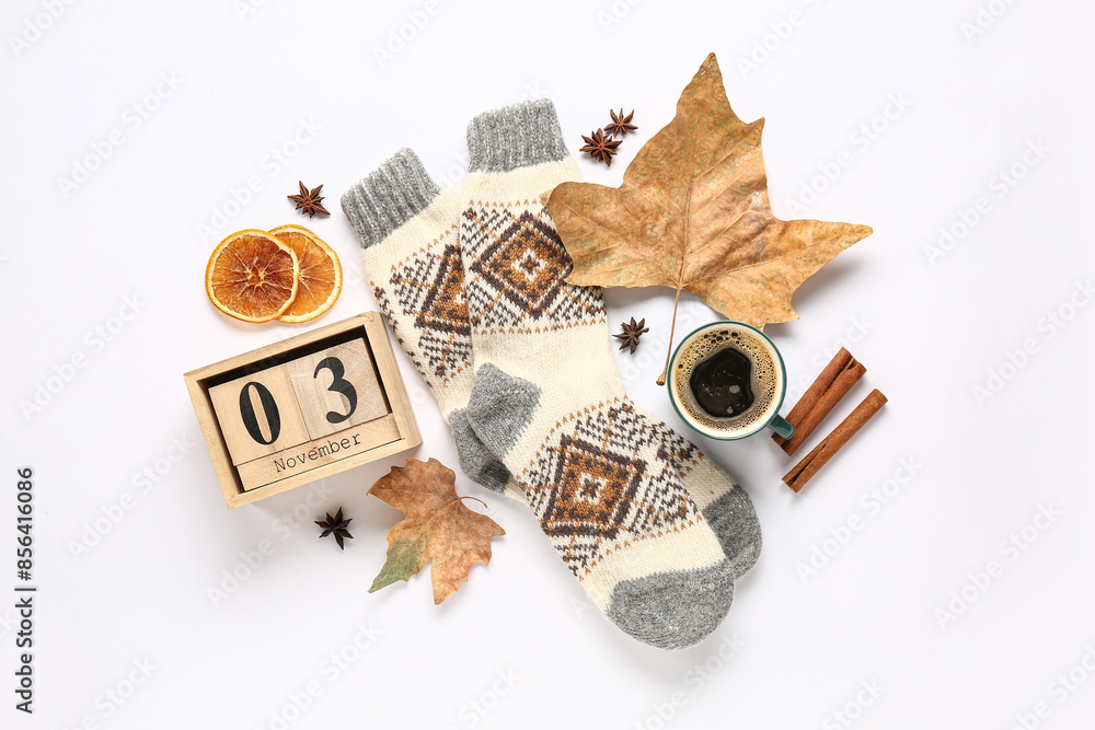 Beautiful composition with warm socks, cube calendar and cup of coffee on white background