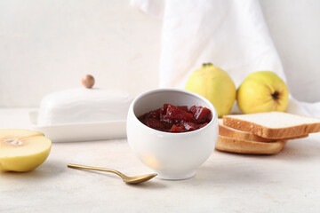 Wall Mural - Bowl of sweet quince jam on white table, closeup