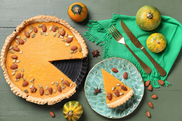 Wall Mural - Delicious pumpkin tart with almond and seeds on green wooden background