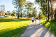 © Austockphoto - Family of three with toddler on suburban walk in afternoon light on footpath