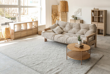 Interior of beautiful living room with comfortable sofa, houseplant and coffee table