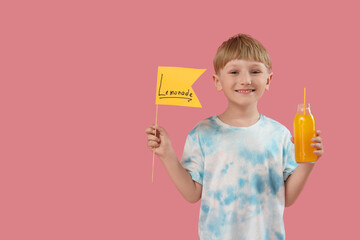 Sticker - Cute little boy holding flag with word LEMONADE and bottle on pink background