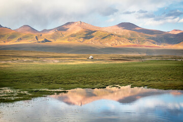 Wall Mural - A lone yurt on the grassland in the mountains near Swan Lake in Bayanbulak Grassland