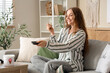 © Pixel-Shot - Young woman with ice cream bucket watching TV at home