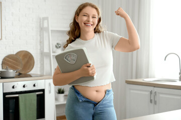 Canvas Print - Happy young woman in tight jeans with scales at home. Weight gain concept