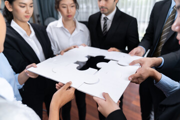 Wall Mural - Multiethnic business people holding jigsaw pieces and merge them together as effective solution solving teamwork, shared vision and common goal combining diverse talent. Meticulous