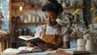 © The Little Hut - Young African American craftswoman watching online educational video and making notes in copybook while sitting by workplace in craft shop : Generative AI