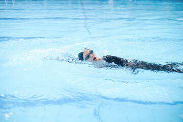 Young Asian Woman In Swimwear Showing Front Crawl Stroke Technique On The Pool