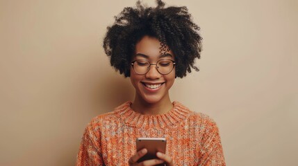 Wall Mural - young black woman looking down at phone smiling 