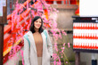 © Itza - Young Latina woman admiring cherry blossoms at a Tokyo shrine, appearing contemplative and serene.