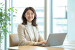 © studio11 - デスクに向かい微笑む日本人の女性ビジネスウーマン