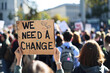 © Emanuel - Rear view of people holding placards and posters during a global climate change strike with the words 'WE NEED A CHANGE'