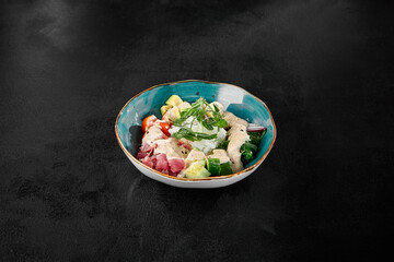 Wall Mural - Delicious Tuna Poke Bowl with Fresh Vegetables and Rice on Dark Background