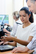 © auremar - woman showing course work to teacher in laptop