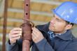 © auremar - male builder working with pipes