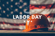 © Larisa - Orange hard hat with Happy Labor Day text on American flag backd
