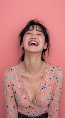 Wall Mural - Young woman with black hair laughing against pink background