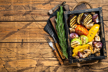 Wall Mural - Assortment of grilled Vegetables in a wooden box, bell pepper, zucchini, eggplant, onion and tomato. Wooden background. Top view. Copy space