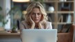 © Photolife   - Tired middle-aged Caucasian business woman in the office in front of a laptop monitor holds her head from irritation and fatigue