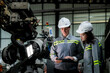 © ultramansk - team engineers inspecting on machine with smart tablet. Worker works at heavy machine robot arm. The welding machine with a remote system in an industrial factory. Artificial intelligence concept.