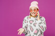 © ViDi Studio - Young surprised lesbian woman wear pink animal clothes talk speak on mobile cell phone look aside on area isolated on plain purple background studio portrait. Pride day June month love LGBTQ concept.