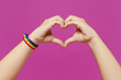 © ViDi Studio - Close up cropped female hold hand in heart shape sign pov sharing love isolated on plain purple color wall background studio. Pride day June month love LGBTQ concept. Copy space advertising mock up.