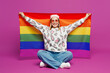 © ViDi Studio - Full body young happy fun lesbian woman wear pink animal clothes hold in hand striped rainbow flag behind herself isolated on plain purple background studio. Pride day June month love LGBTQ concept.