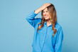 © ViDi Studio - Young sad shocked woman wearing shirt casual clothes puts hand on face facepalm epic fail mistaken omg gesture isolated on plain pastel light blue cyan background studio portrait. Lifestyle concept.