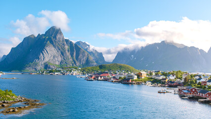 Wall Mural - A panoramic view of a charming village nestled amidst towering mountains and a sparkling fjord in Norway. Reine, Lofoten, Norway