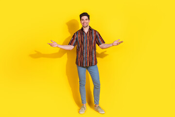 Full size photo of nice young man arms welcome you wear shirt isolated on yellow color background