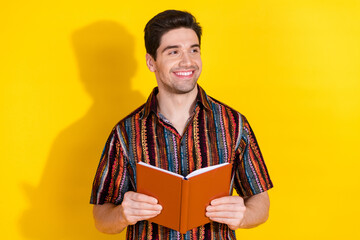 Sticker - Photo of nice young man hold book look empty space wear shirt isolated on yellow color background