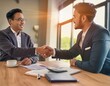 © amol - A young professional shaking hands with a new employer in an office setting.
