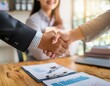 © amol - A young professional shaking hands with a new employer in an office setting.
