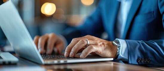 Wall Mural - A man is typing on a laptop computer