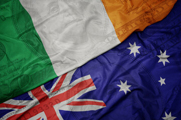 Wall Mural - waving colorful flag of ireland and national flag of australia on the dollar money background. finance concept.