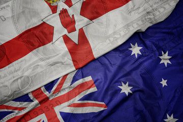 Wall Mural - waving colorful flag of northern ireland and national flag of australia on the dollar money background. finance concept.