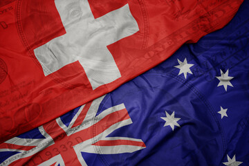 waving colorful flag of switzerland and national flag of australia on the dollar money background. finance concept.
