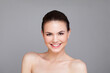 © artmim - Nice young adult woman with healthy fresh clear skin looking at camera posing on grey background. Beautiful face of female model with natural cosmetic, studio portrait
