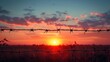 © vixion - Barbed Wire Silhouette Against a Dramatic Sunset