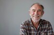 © CogniLens - Portrait of a happy caucasian man in his 60s smiling at the camera isolated in blank studio backdrop