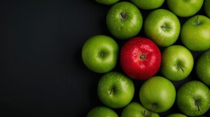 Single Red Apple Among Green Apples on Black Background Highlighting Uniqueness and Contrast